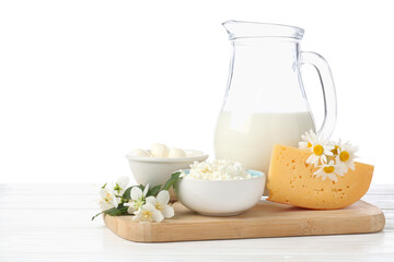 Different fresh dairy products and flowers on wooden table against white background