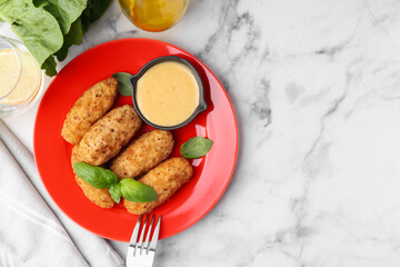 Tasty fried croquettes, basil and sauce served on white marble table, flat lay. Space for text