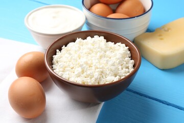 Different dairy products and eggs on light blue wooden table, closeup