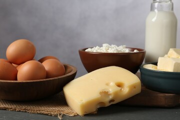 Different dairy products and eggs on grey wooden table, closeup