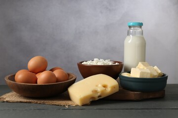 Different dairy products and eggs on grey wooden table