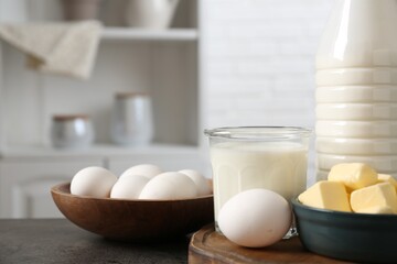 Different dairy products and eggs on gray textured table in kitchen, closeup
