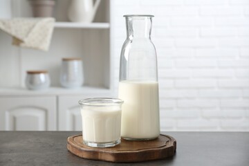 Dairy products. Fresh milk in glass and bottle on gray textured table indoors