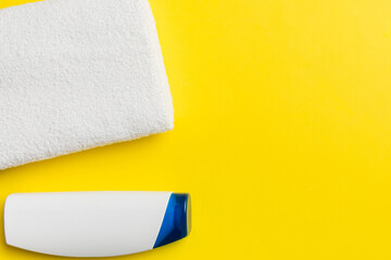 Cosmetic shampoo bottle mockup with towels on a colored table. Bathroom background, toilet...