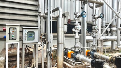 gas pump station, Large industrial pumps and insulated piping system in a modern chiller plant. Key components for thermal energy transfer and HVAC operations in commercial or industrial facilities.