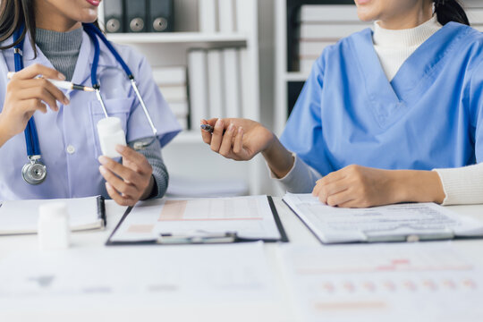 Female doctor is in a meeting to discuss the analysis of documents from trials on the efficacy of a new drug. - Powered by Adobe