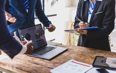 Business team analyzing financial data on laptop during a meeting. Businesspeople discussing report...