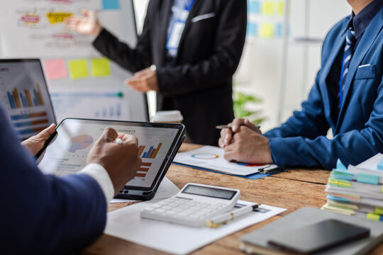 Business people analyzing financial data on digital tablet and laptop. Business team analyzing financial data on digital device in office, discussing strategy for growth and success.