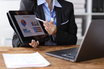 Asian businesswoman showing financial charts during video call.