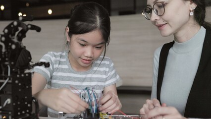 teacher teaches students about creating and designing robots in classroom