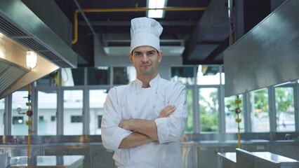 Portrait of young male chef standing with his arms crossed in the kitchen