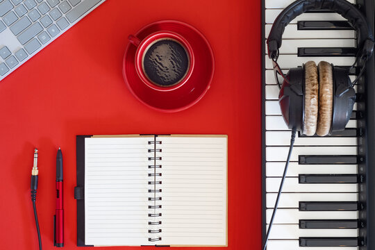 Flat lay of music workspace. Headphones, keyboard and creative journal.
