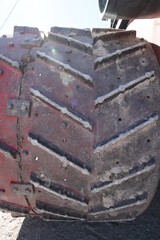The back of a vintage steam powered tractor wheel in made of all metal with pieces that stick out...