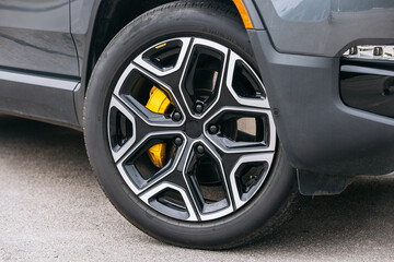 Close-up of a modern car wheel. The details of the tire tread and rim are clearly visible, emphasizing the technology and style of the vehicle