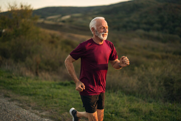Senior Man Jogging Outdoors in Scenic Countryside Landscape