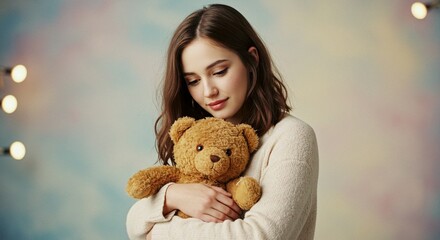 A young woman embraces a brown teddy bear against a soft, blurred background, creating a feeling of warmth and comfort.