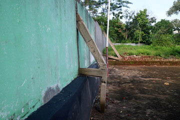 Weathered Green Wall with Wooden Supports