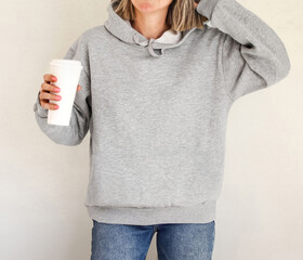 Hoodie sweatshirt long sleeve mockup. Girl wearing blank gray hoodie sweatshirt with copy space for...
