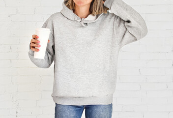 Hoodie sweatshirt long sleeve mockup. Girl wearing blank gray hoodie sweatshirt with copy space for...