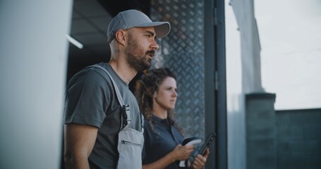 Male Worker and Female Manager with Tablet Computer Standing Outside of Logistics Retail Warehouse,...