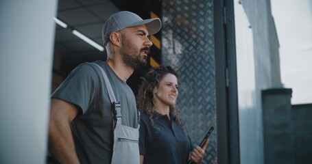 Male Worker and Female Manager with Tablet Computer Standing Outside of Logistics Retail Warehouse, Giving Instructions to Delivery Truck, Working in Express Delivery Service. E-Commerce Online Orders