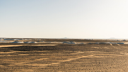 Ash-covered hills in Egypt's Black Desert under a clear sky, scenic and remote landscape. Volcanic	