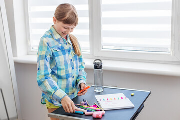 Smiling child organizing colorful markers at desk