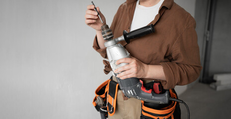 Close-up female repairwoman hands inserting drill bit