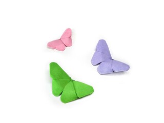 Origami paper butterflies in pink, green and purple on a white background.