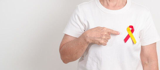 World hepatitis day awareness month, 28 July. elderly woman with Red and Yellow ribbon. Liver...