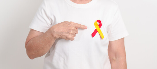 World hepatitis day awareness month, 28 July. elderly woman with Red and Yellow ribbon. Liver...