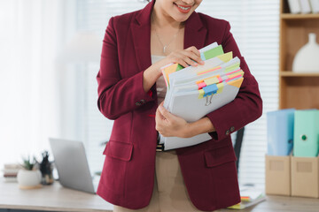 Businesswoman reviewing documents: A closeup of a businesswoman carefully reviewing a stack of...