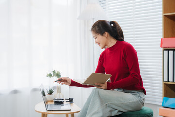 Modern Workspace: A young professional, bathed in natural light, focuses intently on her work...