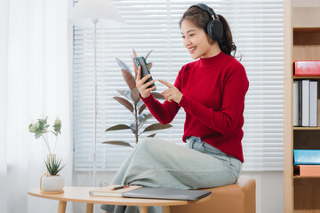 Woman in Video Call: An Asian woman, adorned in a vibrant red sweater and wearing headphones,...
