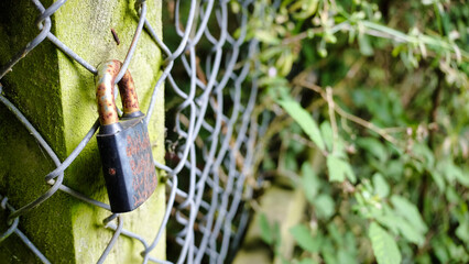 rusty padlock on a wire fence