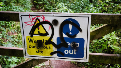 warning sign covered in graffiti
