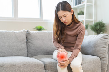 Health care of knee pain concept, suffering asian young woman arthritis sitting joint ache, sore...