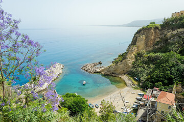 Italian Coastal Serenity — Aerial View of Sea with Boat and Purple Flowers © Rena