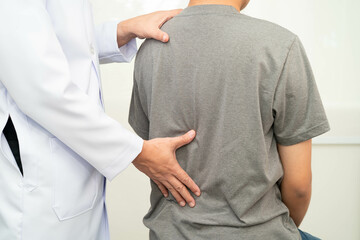 Physical therapy, Asian therapist doctor treat perform pain young man in hospital.