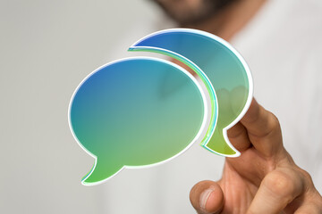 Image of a person holding digital speech bubbles, ideal for communication, conversation, and...