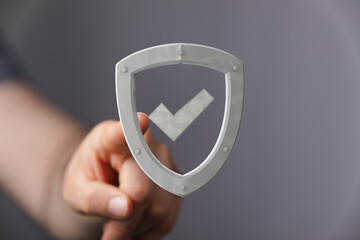 Image of a hand selecting a digital shield icon, representing data security and protection.