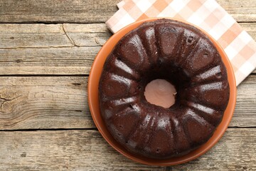 Tasty chocolate bundt cake on wooden table, top view. Space for text