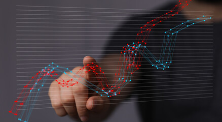 Stock photo of hand interacting with a digital graph showing business growth and data analysis.