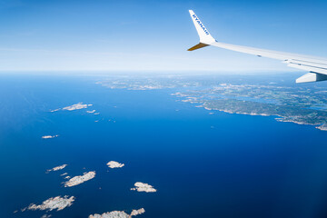 View from the window of a Ryanair plane over the sea and land of Norway.