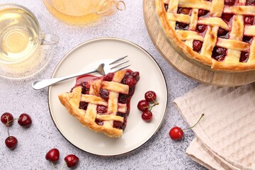Tasty cherry pie, berries and tea on grey textured table, flat lay