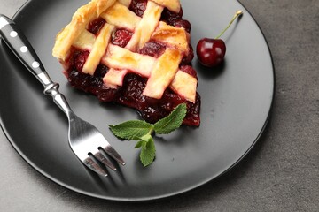 Piece of tasty cherry pie and berries on grey table, closeup