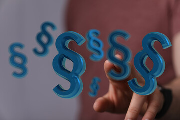 Abstract image of a hand interacting with floating paragraph symbols, ideal for legal, law, and...