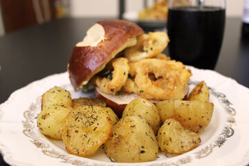 Delicious burger revisited with calamari with tartar sauce and baked potatoes with herbs and olive...
