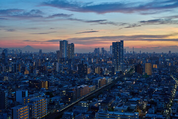 Obraz premium Dusk in Tokyo with Mount Fuji Silhouette and Commuter Train Lights
