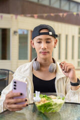 Non binary gay man eating salad